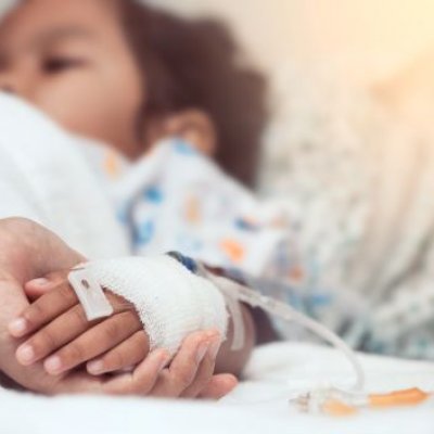 Sick child in a hospital bed with a drip 